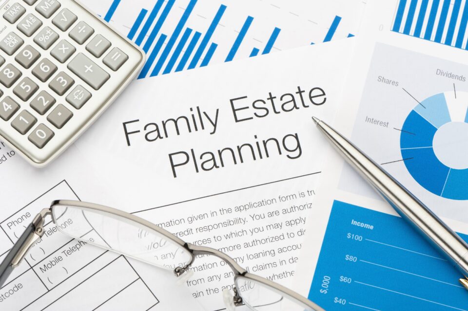 Family Estate Planning document beside a calculator, pen, and pie chart on a desk