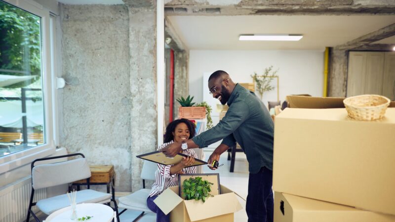 Woman helping a man review documents while he sits in a living room chair